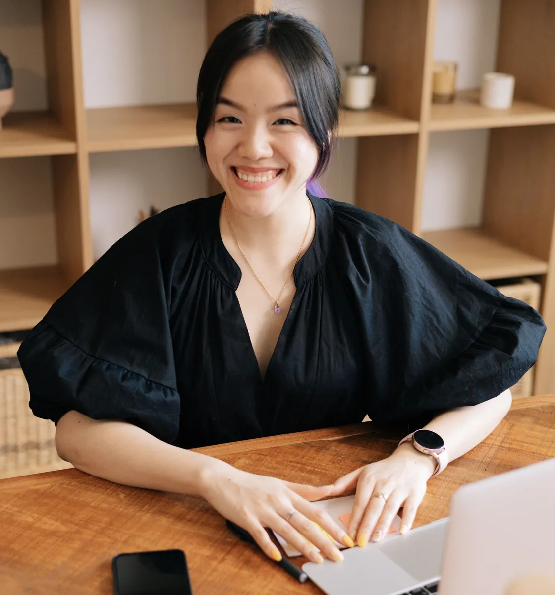Smiling founder at her laptop in a bright office